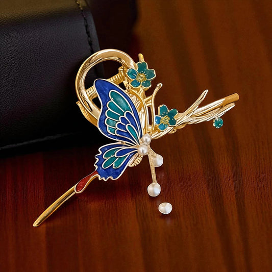 TITLIYA blue and teal enamel butterfly hair clip with gold-tone metal, floral accents, and dangling pearl beads.
