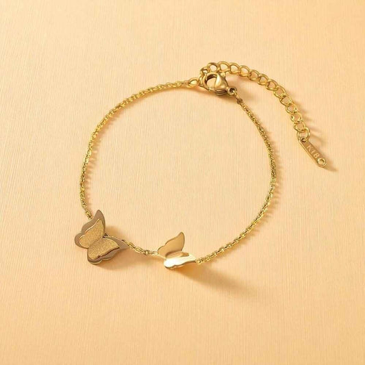 TITLIYA gold-tone link bracelet featuring a textured glitter butterfly and a polished smooth butterfly charm.