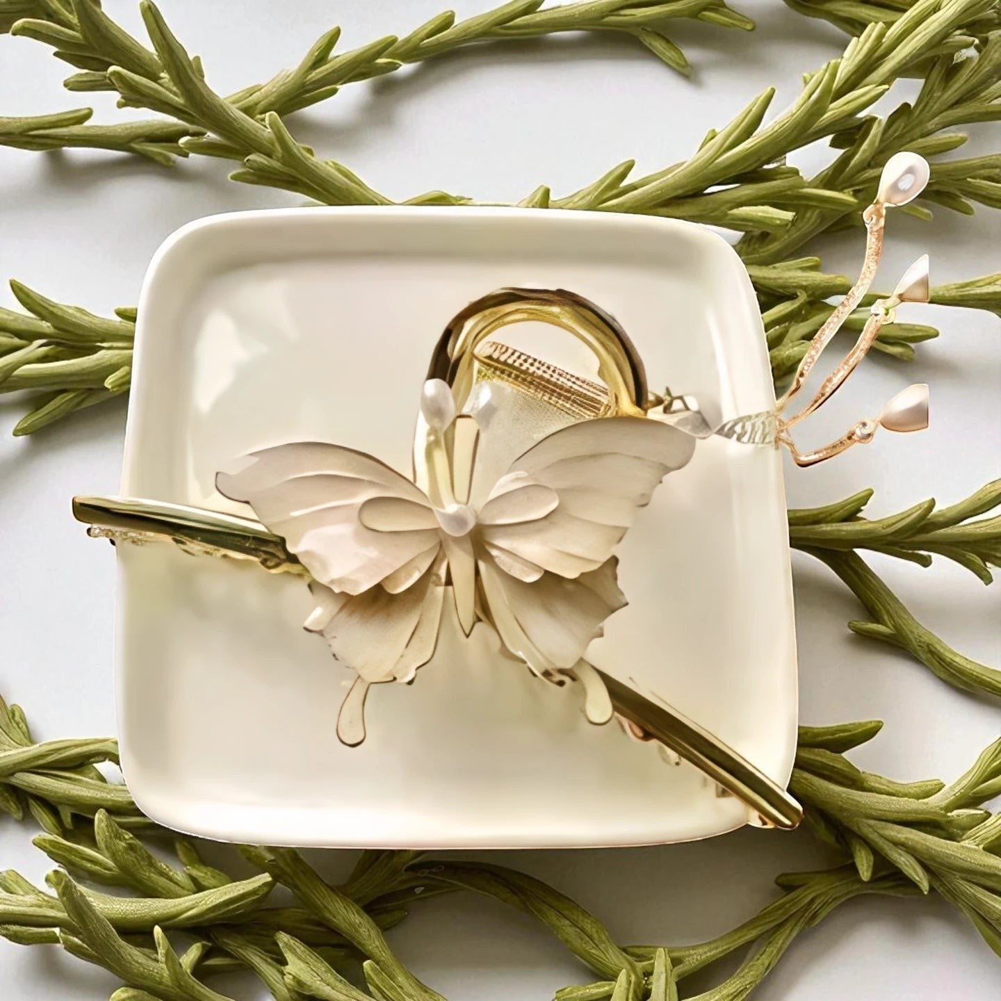 TITLIYA off-white butterfly hair claw clip with gold-tone metal, faux pearls, and dangling chain accents.