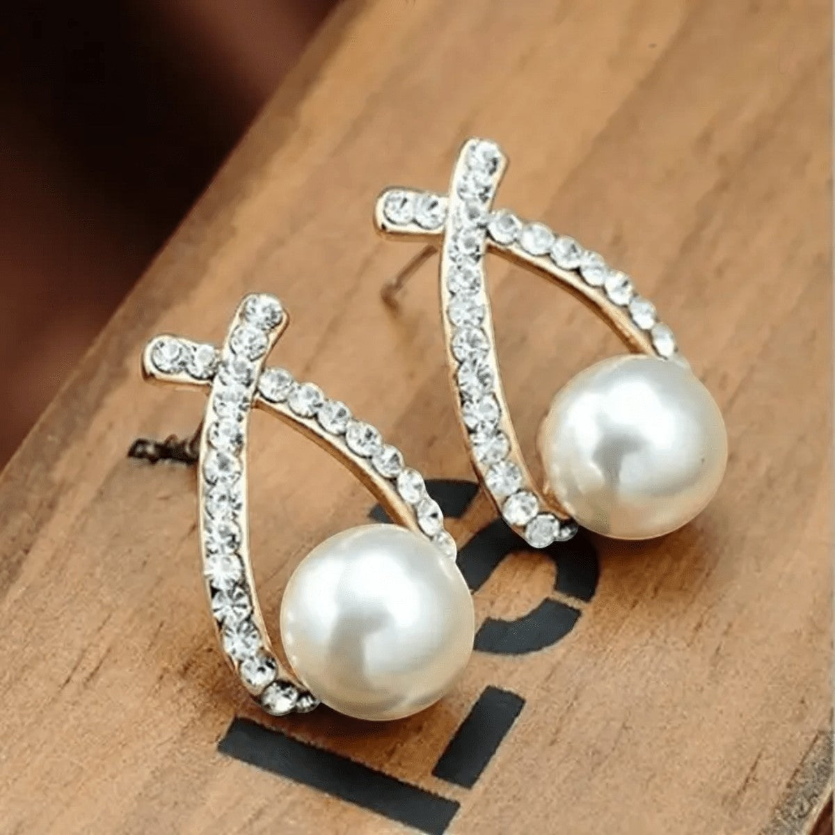 TITLIYA double cross earrings featuring sparkling crystals and a central white pearl in a gold-tone setting.