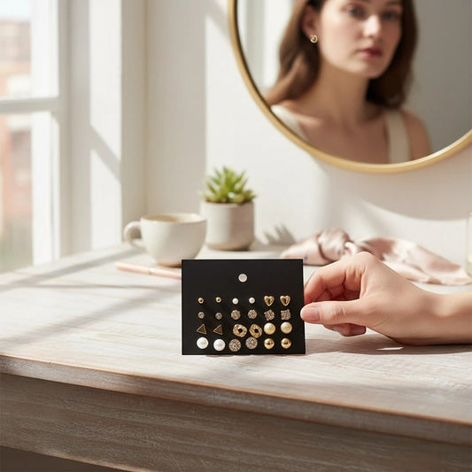 TITLIYA set of 12 gold-toned stud earrings featuring hearts, pearls, and textured designs on a black display card.