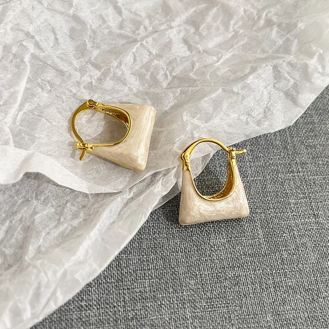 TITLIYA gold-toned hoop earrings featuring a unique cream-colored handbag shape for a stylish, elegant look.
