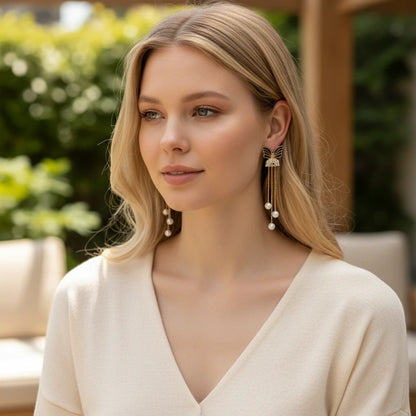 Model wearing TITLIYA premium Korean-style black butterfly earrings with gold chains and hanging white pearls.