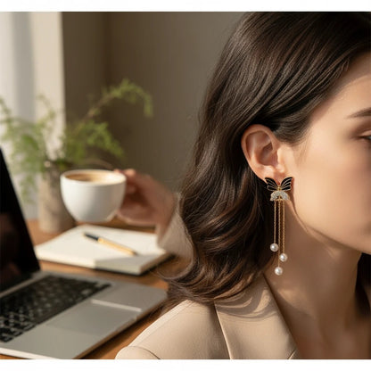 TITLIYA black butterfly earrings with pearl tassels and crystal accents worn by a woman in a professional setting.