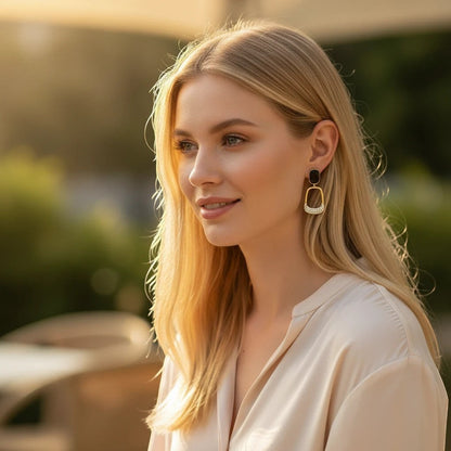 Blonde woman wearing TITLIYA black and gold Korean drop earrings with pearl accents for an elegant daily look.