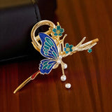 TITLIYA blue and teal enamel butterfly hair clip with gold-tone metal, floral accents, and dangling pearl beads.