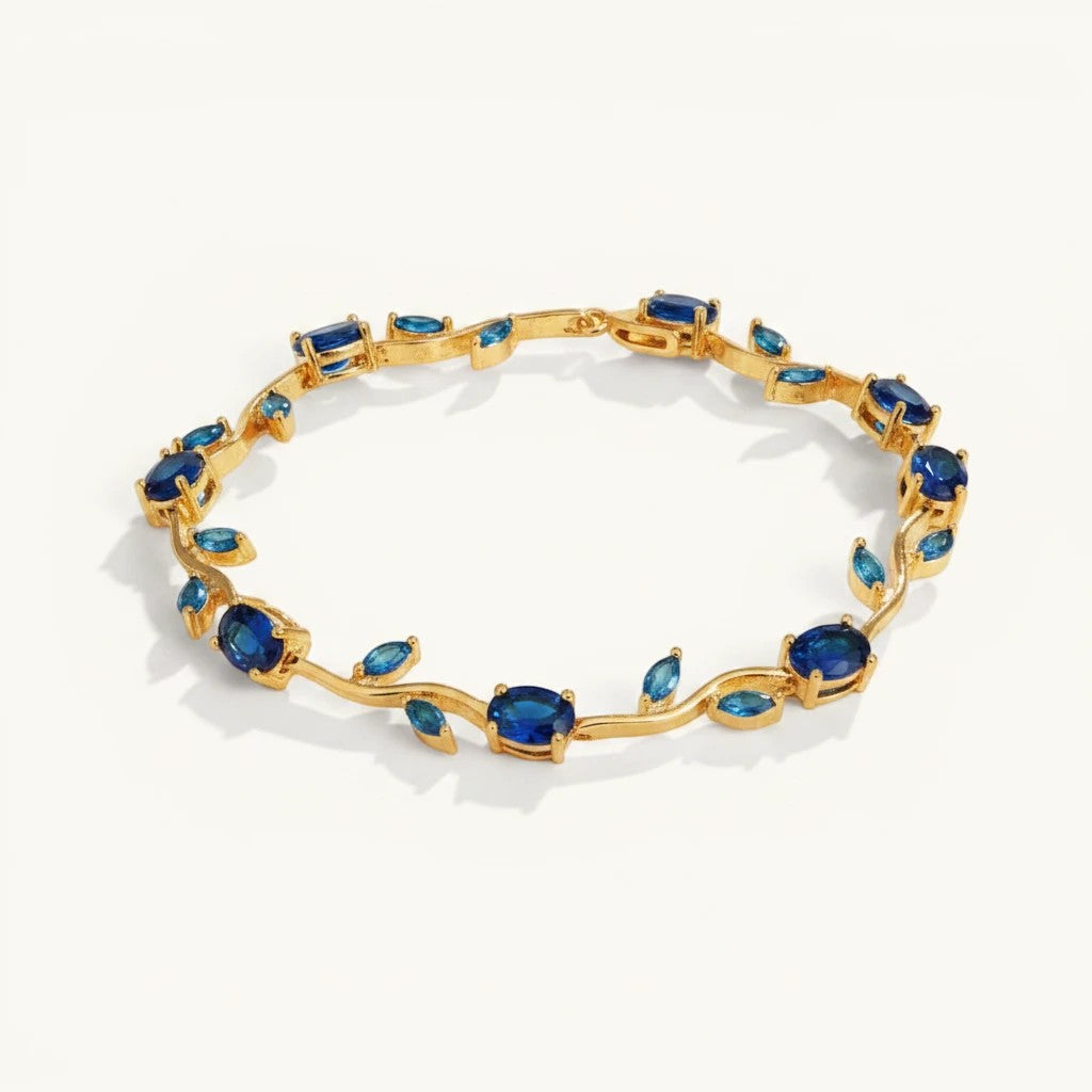 TITLIYA Blue Tulip Bracelet featuring a gold-tone vine design with oval-cut deep blue stones on a white background.