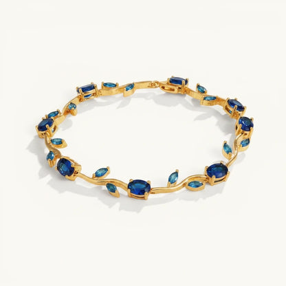 TITLIYA Blue Tulip Bracelet featuring a gold-tone vine design with oval-cut deep blue stones on a white background.