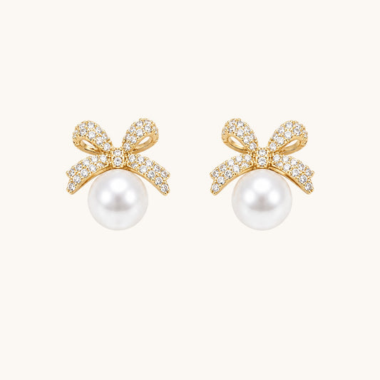 TITLIYA gold-toned bow stud earrings featuring sparkling cubic zirconia stones and a lustrous white pearl drop.