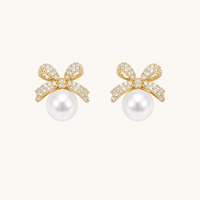 TITLIYA gold-toned bow stud earrings featuring sparkling cubic zirconia stones and a lustrous white pearl drop.