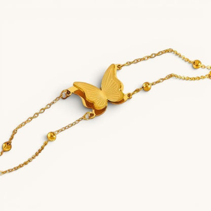 TITLIYA gold-tone butterfly charm bracelet with delicate chain and polished bead accents on a white background.