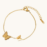 TITLIYA gold-tone link bracelet featuring one textured glitter butterfly charm and one smooth polished butterfly charm.