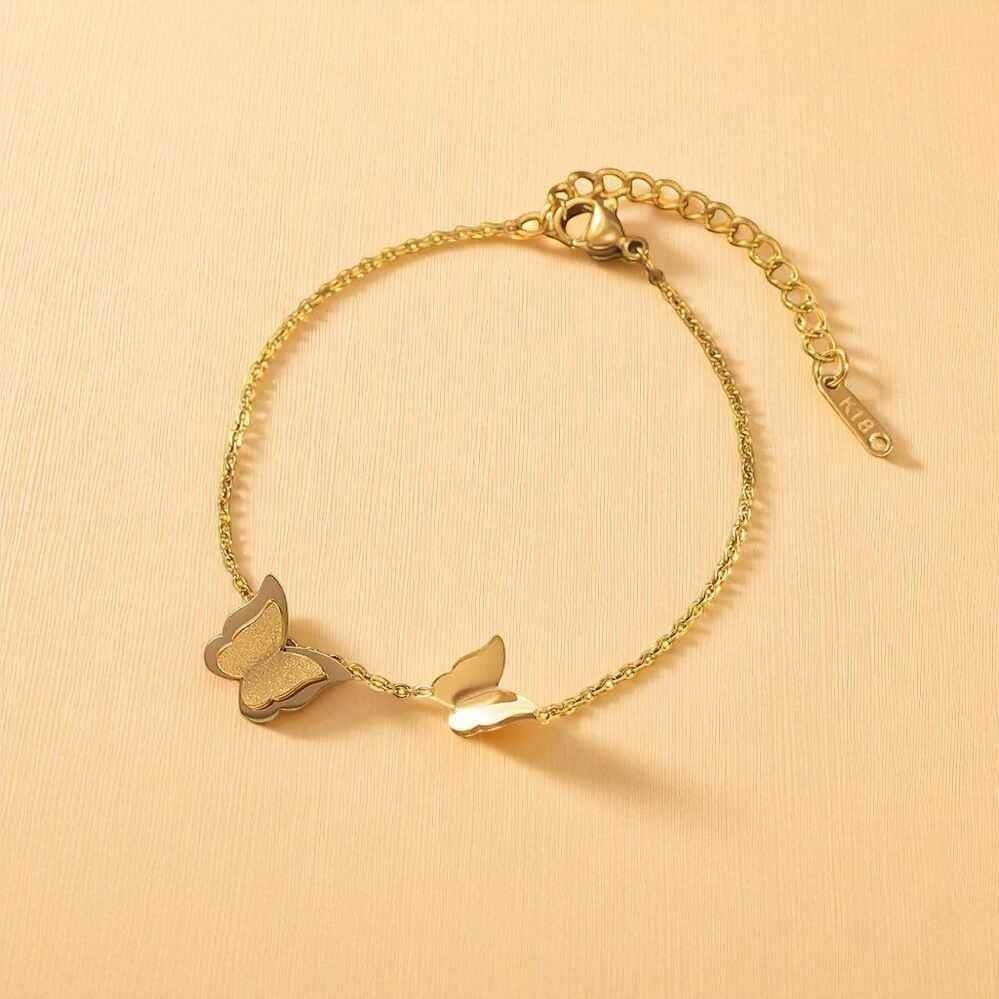 TITLIYA gold-tone link bracelet featuring a textured glitter butterfly and a polished smooth butterfly charm.