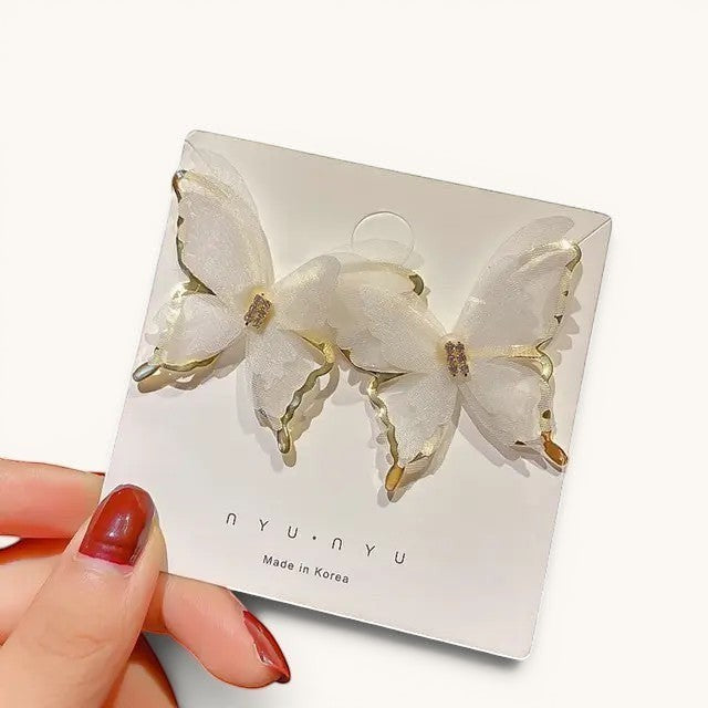 TITLIYA Korean style butterfly earrings with white sheer fabric wings, gold trim, and crystal accents on display.