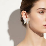 Model wearing TITLIYA Korean style butterfly earrings with sheer white fabric wings, gold trim, and crystal accents.