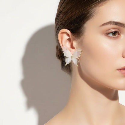 Model wearing TITLIYA Korean style butterfly earrings with sheer white fabric wings, gold trim, and crystal accents.