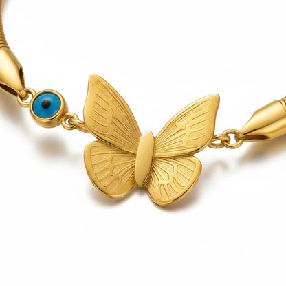 TITLIYA gold-tone snake chain bracelet featuring a butterfly charm and a blue evil eye bead for protection.