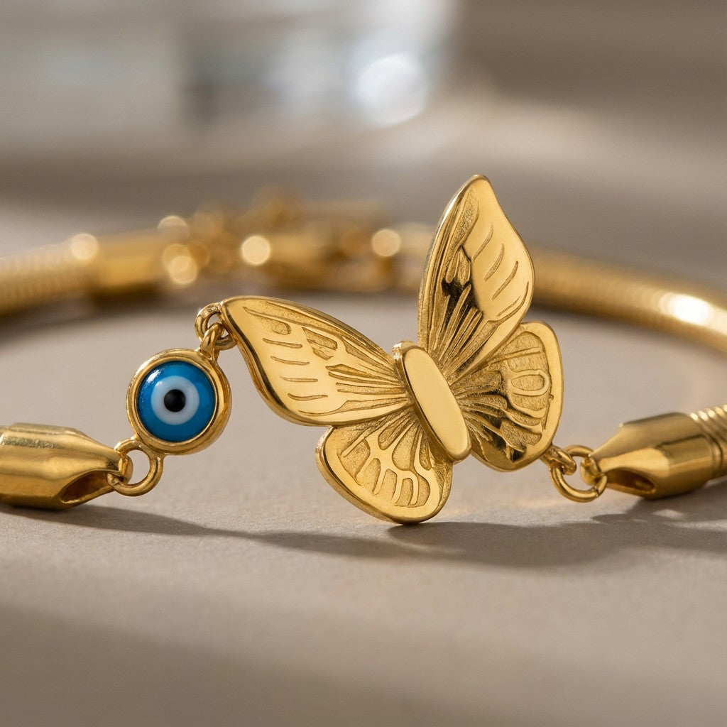 TITLIYA gold-tone boho bracelet featuring a butterfly charm and a blue evil eye bead on a sleek chain.