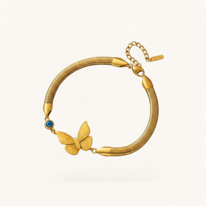 TITLIYA gold-tone snake chain bracelet featuring a butterfly charm and a blue evil eye bead in a boho style.