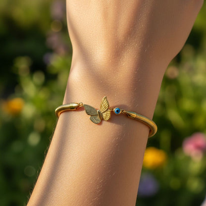 TITLIYA gold-tone boho bracelet featuring a butterfly charm and a blue evil eye bead worn on a wrist outdoors.