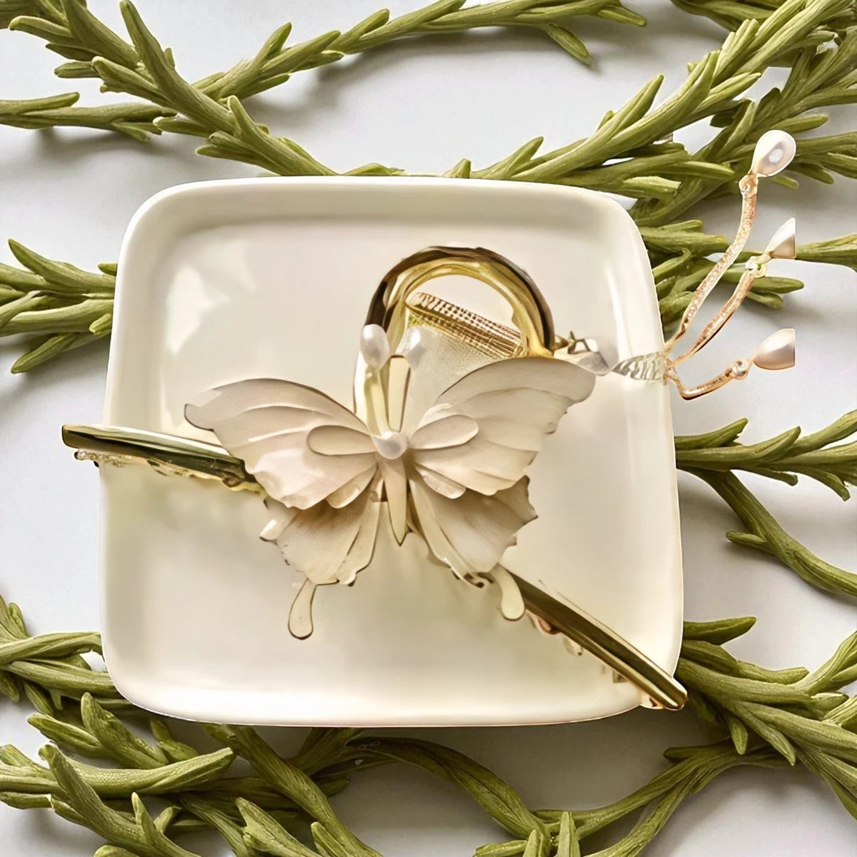 TITLIYA off-white butterfly hair claw clip with gold-tone metal, faux pearls, and dangling chain accents.