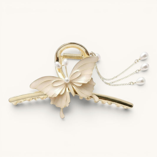 TITLIYA off-white enamel butterfly hair claw clip with gold-tone metal base and dangling faux pearl chain accents.