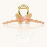 TITLIYA butterfly hair claw in pink and cream enamel with a polished gold finish and non-slip jaw grip.