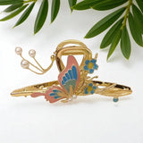 TITLIYA gold-tone butterfly hair clip with pink and blue enamel, dangling pearls, and floral accents.