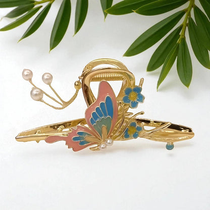 TITLIYA gold-tone butterfly hair clip with pink and blue enamel, dangling pearls, and floral accents.