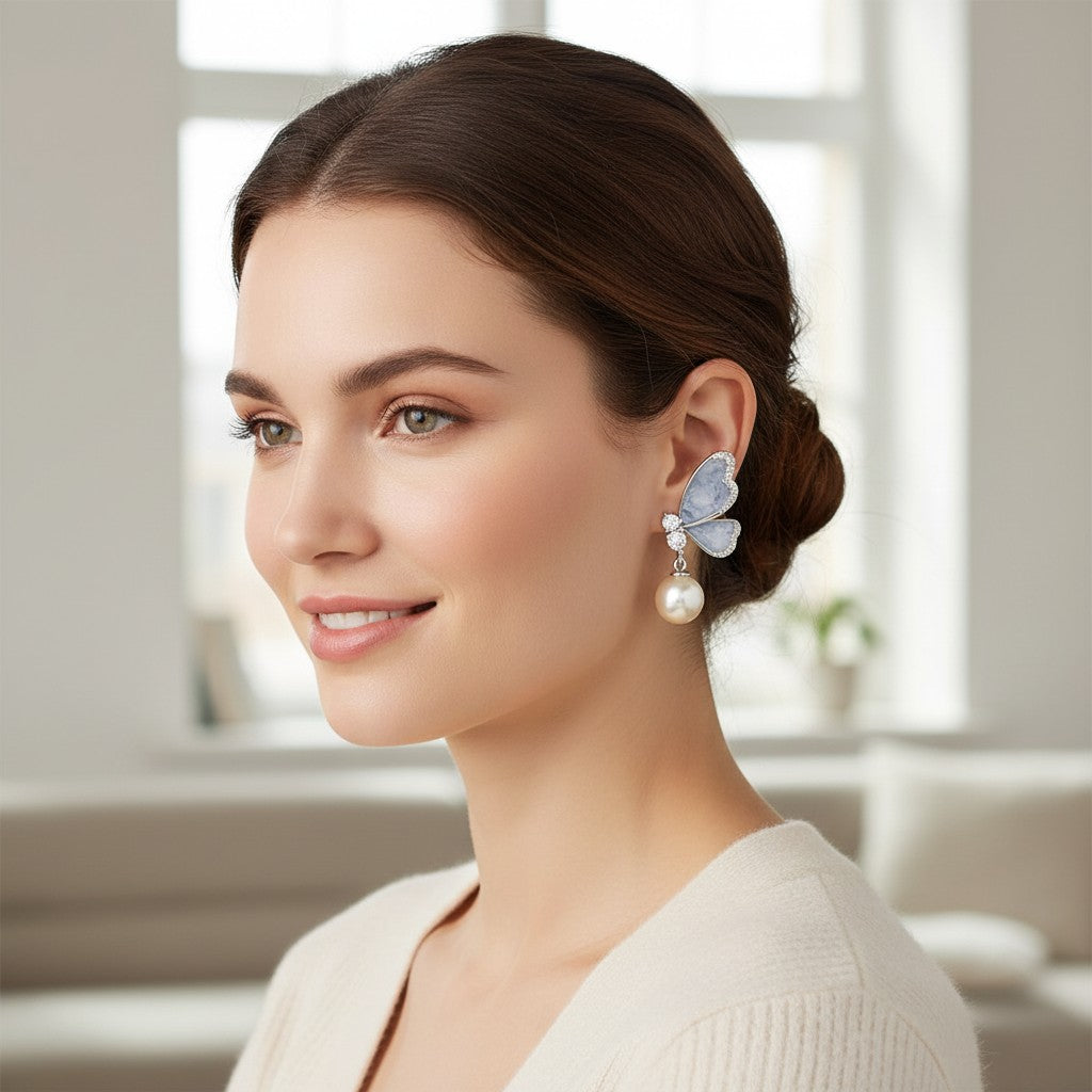 TITLIYA butterfly drop earrings with icy blue artificial stone, crystal accents, and a pearl drop on a smiling model.