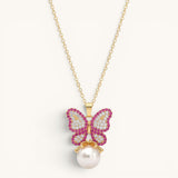TITLIYA gold-tone alloy butterfly pendant necklace with pink and white crystals and a dangling white pearl charm.