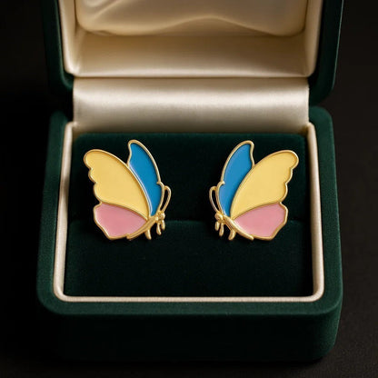 TITLIYA colourful stainless steel butterfly earrings with blue, yellow, and pink enamel in a green velvet jewelry box.