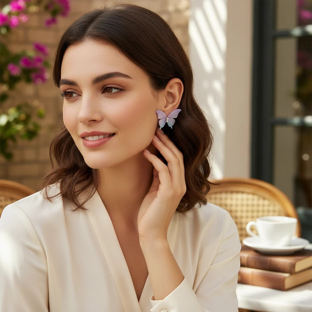 Woman wearing TITLIYA feather-light butterfly stud earrings in pastel purple and blue, styled for a chic daily look.