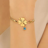TITLIYA gold-tone snake chain bracelet featuring a heart-leaf clover charm and a small blue evil eye pendant.