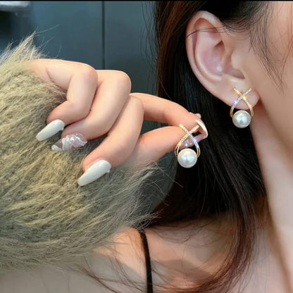 TITLIYA diamond studded cross pearl stud earrings worn by a woman, featuring elegant gold-tone metal and white pearls.