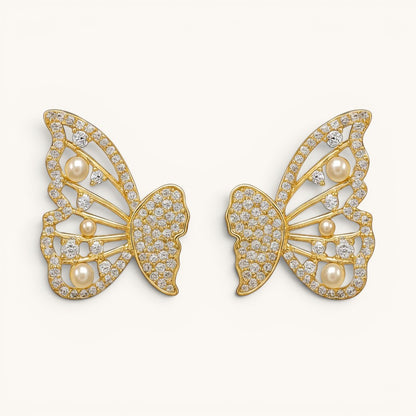 TITLIYA gold-tone butterfly stud earrings featuring sparkling crystals and small white pearls for an elegant look.