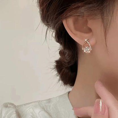 TITLIYA rose gold crystal cross-shaped Korean earring worn on a woman's ear for an elegant daily look.