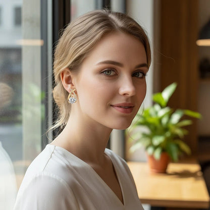 Woman wearing a TITLIYA gold-tone crystal cross earring with a sparkling round stone in a stylish Korean design.