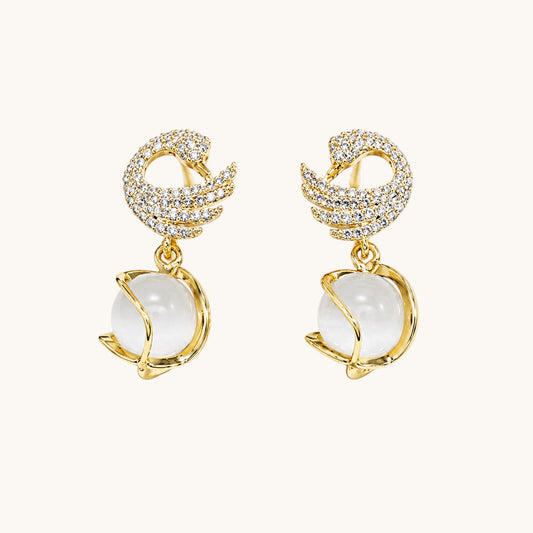 TITLIYA gold-plated dove shape earrings featuring crystal pavé wings and a dangling white moonstone sphere.