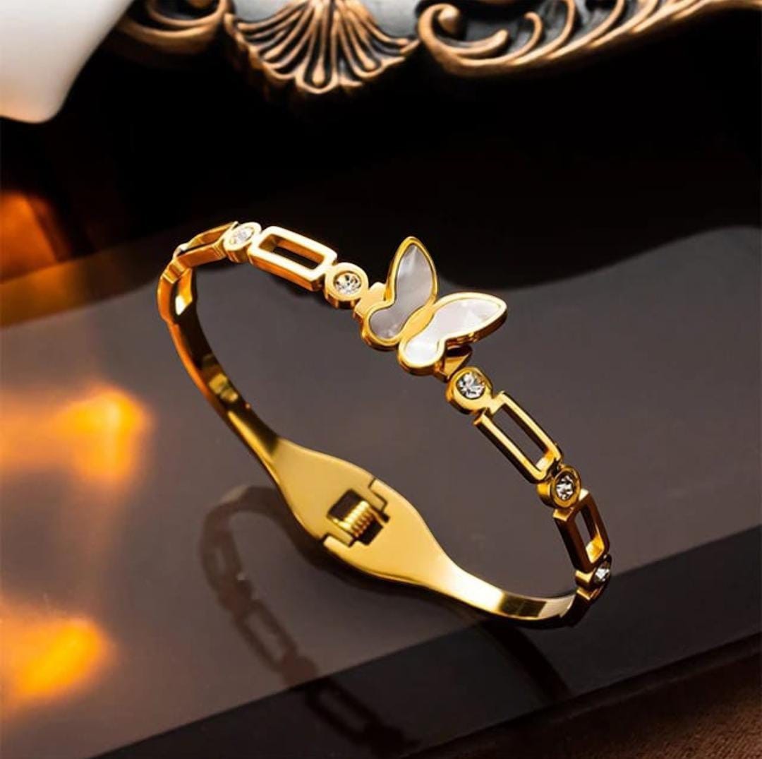 TITLIYA gold-plated butterfly bracelet with pearlescent center and crystal accents on a polished chain-link band.