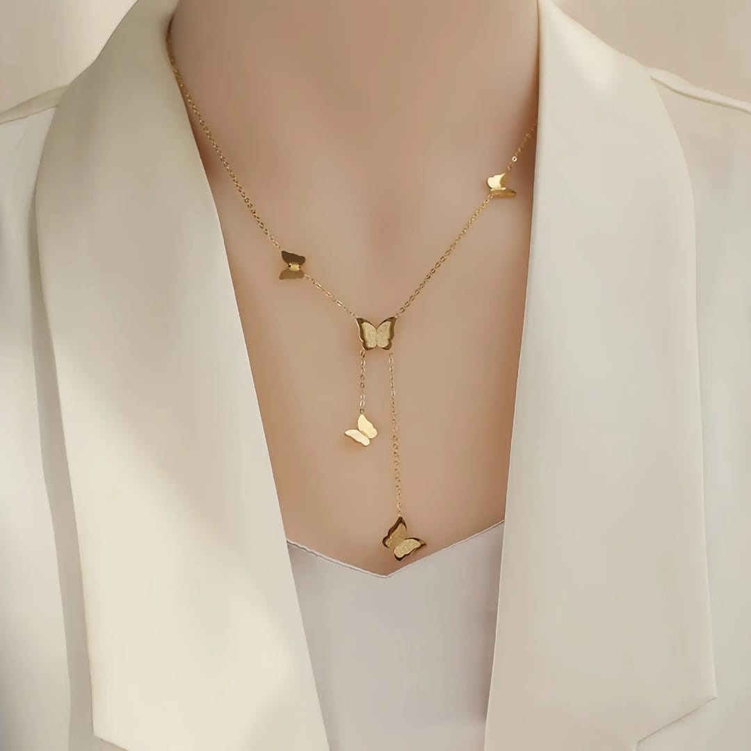 TITLIYA gold glitter butterfly lariat necklace worn on a model in a white blazer for an elegant everyday look.