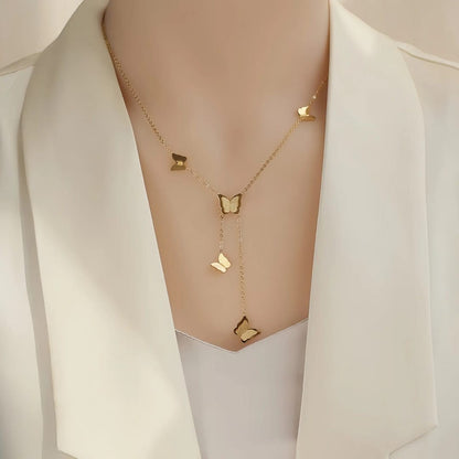 TITLIYA gold glitter butterfly lariat necklace worn on a model in a white blazer for an elegant everyday look.