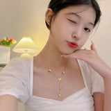 Woman wearing a delicate gold butterfly necklace by TITLIYA, featuring multiple butterfly charms on a thin chain.
