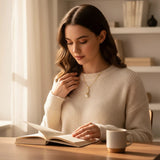 Woman in cream sweater wearing a TITLIYA gold-toned butterfly necklace with crystal accents and a faux pearl drop.