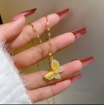 TITLIYA gold-toned butterfly pendant necklace with yellow opal-style wings and crystal accents on a delicate chain.