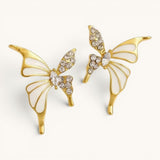 TITLIYA gold-plated butterfly stud earrings featuring white enamel wings and sparkling crystal accents.