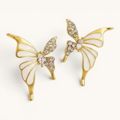TITLIYA gold-plated butterfly stud earrings featuring white enamel wings and sparkling crystal accents.