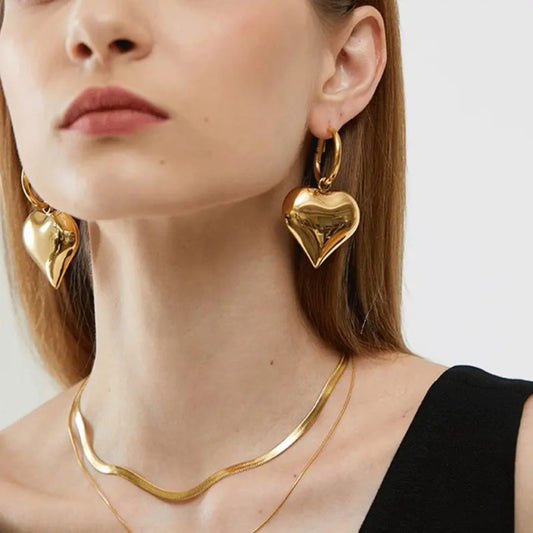 Model wearing TITLIYA gold-plated heart-shaped hoop earrings with a sleek chain necklace for an elegant look.