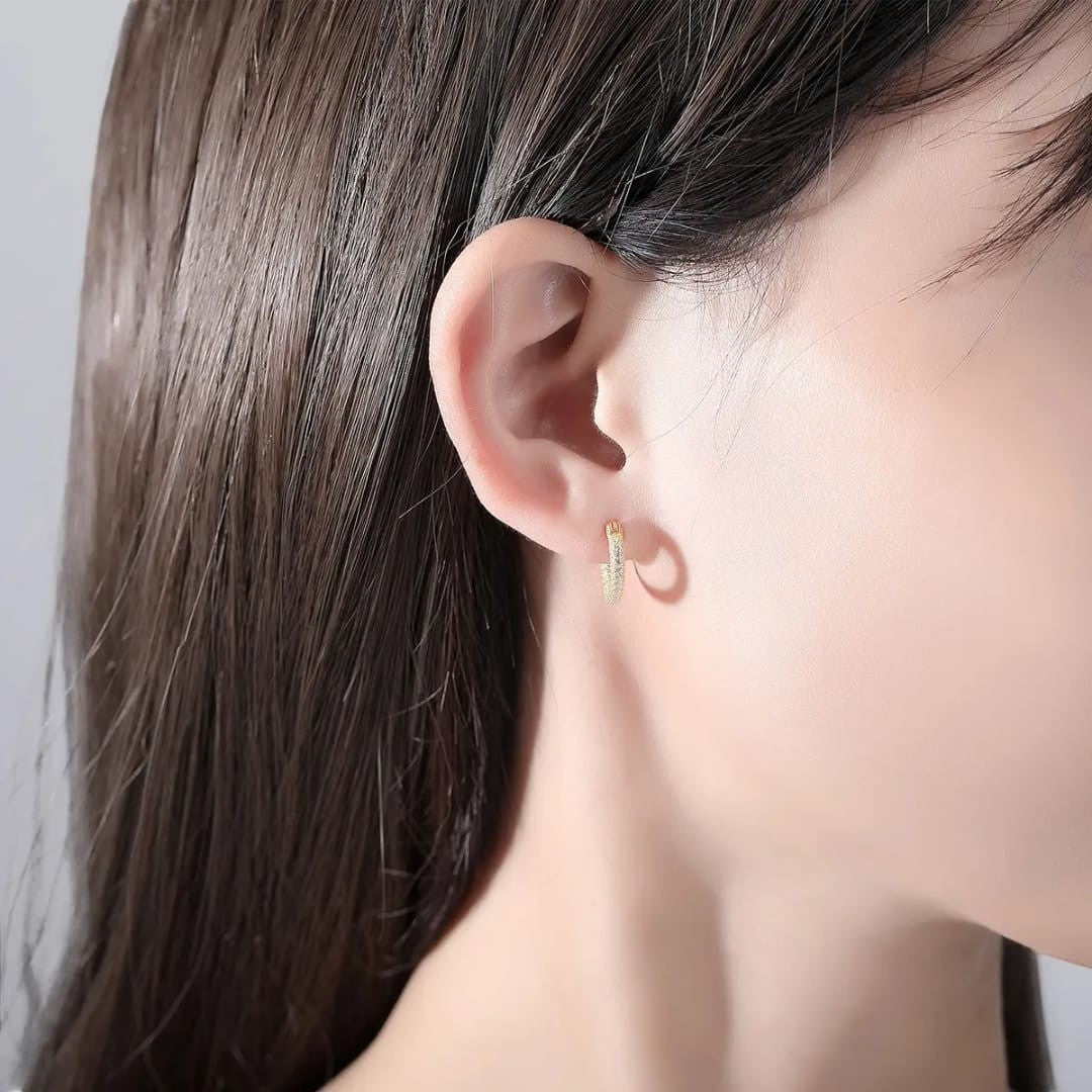 TITLIYA gold-plated mini hoop earrings with delicate stone embellishments worn on a woman's ear for daily elegance.