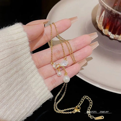 TITLIYA gold plated necklace featuring a delicate bow pendant with crystals and two dangling white pearls